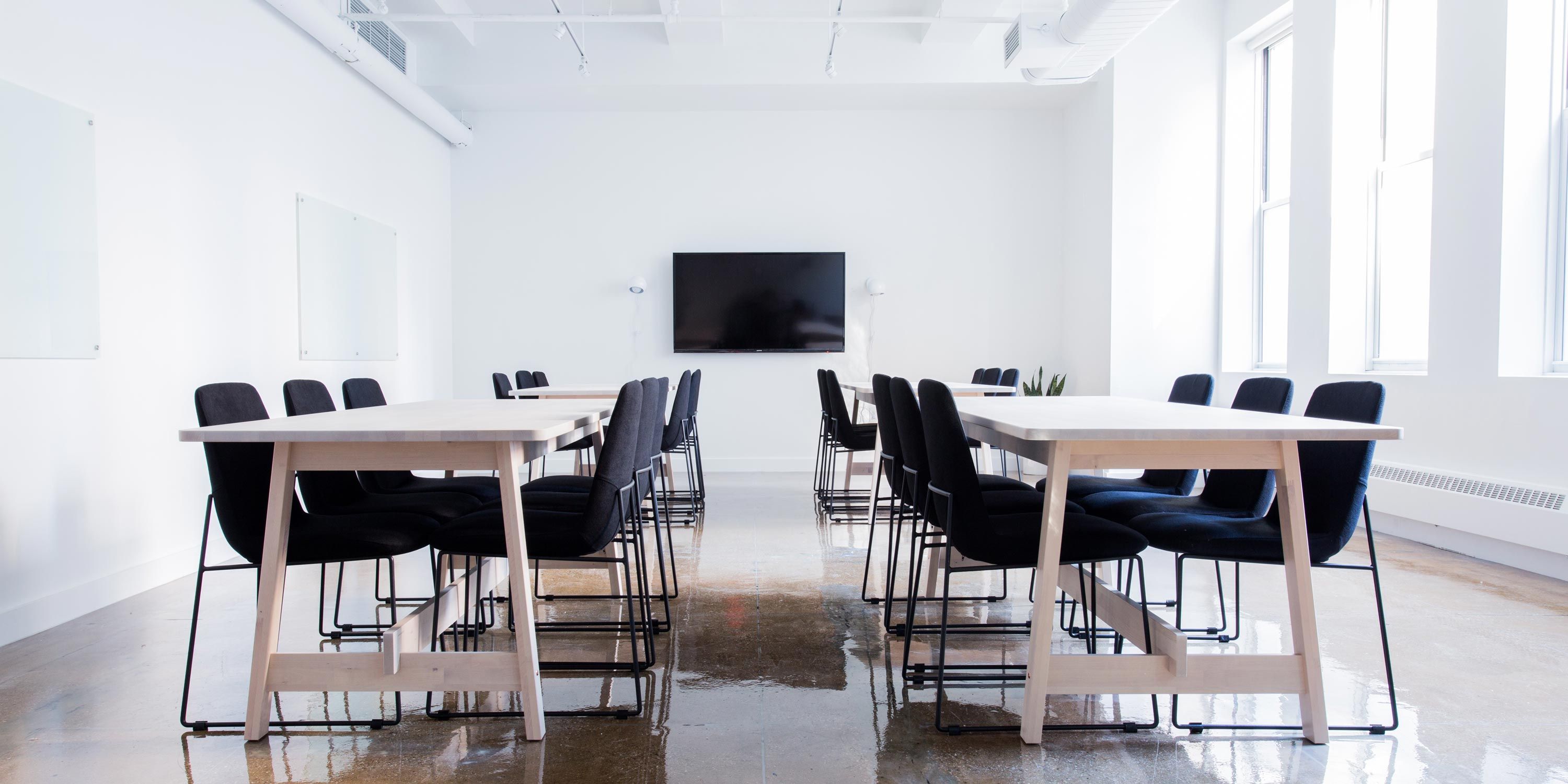 huddle room with wooden table and black chairs